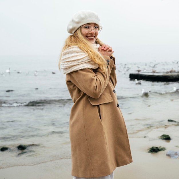 Gratis foto gelukkige vrouw op het strand in de winter