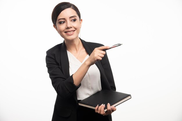 Gelukkige vrouw poseren met notebook op witte achtergrond. Hoge kwaliteit foto