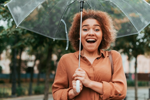 Gelukkige vrouw stond onder haar paraplu in de herfst