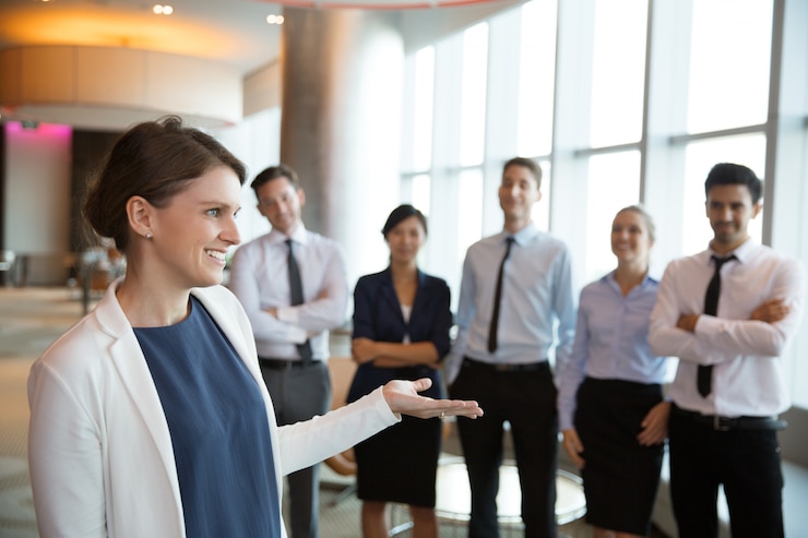 Gratis Foto gelukkige vrouwelijke executive manager bij team