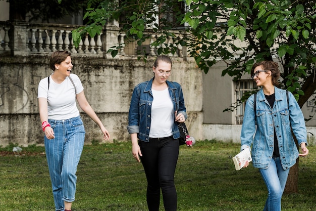 Gelukkige vrouwelijke vrienden die in park lopen