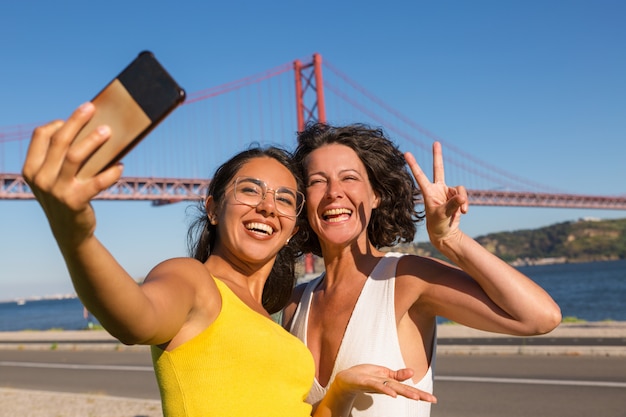 Gelukkige vrouwelijke vrienden die voor selfie stellen