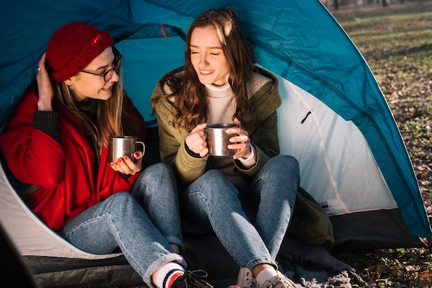 Gelukkige vrouwen die in tent zitten