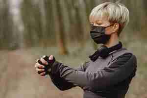 Gratis foto gemaskerde vrouw training tijdens coronavirus