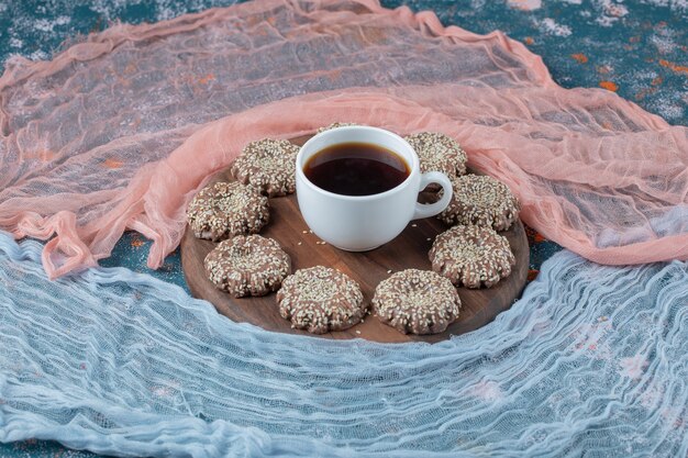 Gember sesam koekjes op een houten schotel.