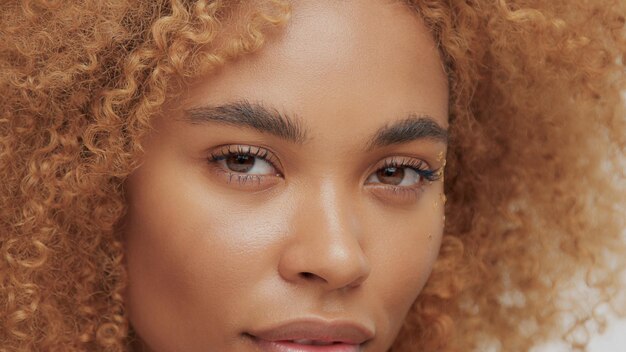 Gemengd ras zwart blond model met krullend haar ogen close-up kijken naar de camera