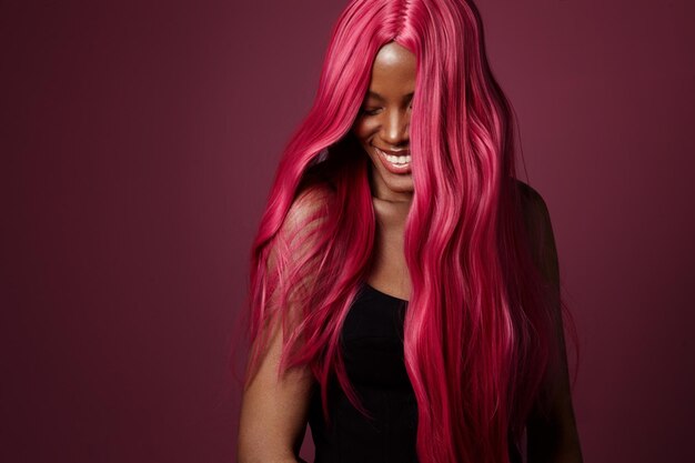 Gemengd ras zwarte vrouw met roze haar gelukkig lachend creatieve haarkleur