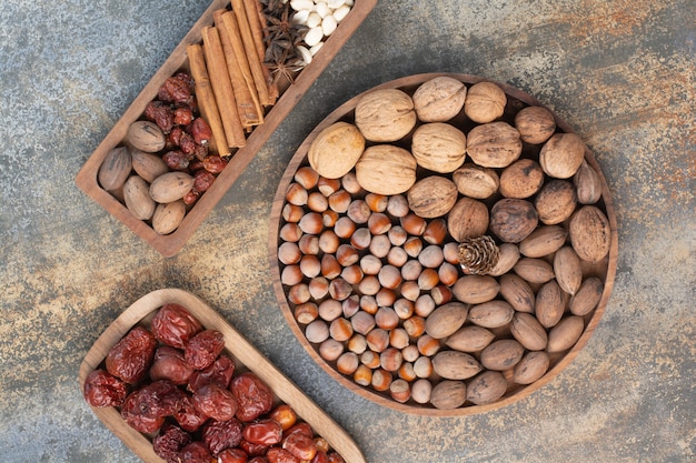 Gemengde noten met pijpjes kaneel en gedroogd fruit op houten plaat. Hoge kwaliteit foto