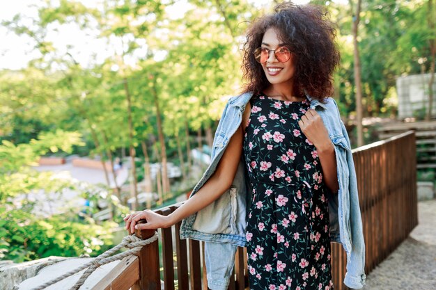 Gemengde rasvrouw met perfecte tanden en haren die haar vrije tijd in park doorbrengen