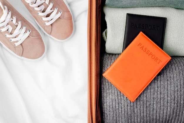 Gratis foto geopende bagage met opgevouwen kleding en paspoort