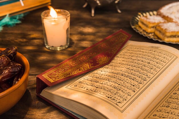 Geopende koran dichtbij kaars en zoete data