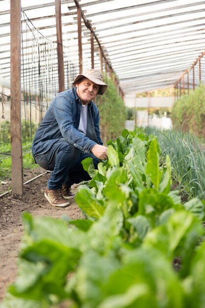 Gepensioneerde man met hoed genieten van planten