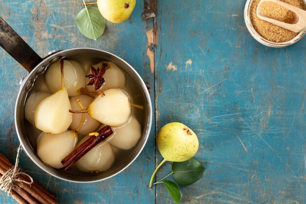 Gepocheerde peren met kruiden op siroop op een blauwe houten achtergrond heerlijk dessert voor de vakantie top uitzicht