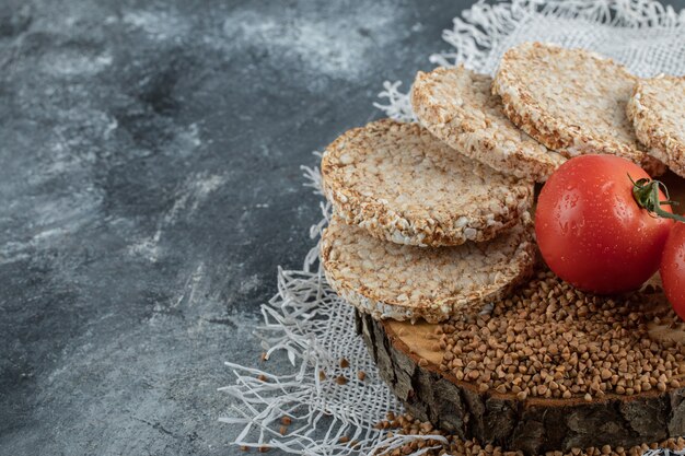 Gepofte knäckebröd, tomaten en rauwe boekweit op marmeren oppervlak