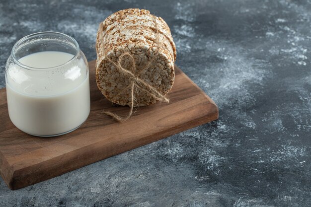 Gepofte rijstwafels en verse melk op een houten bord