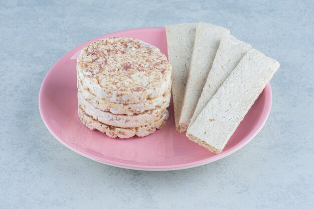 Gepofte rijstwafels en zoete cracker in de plaat op marmer.