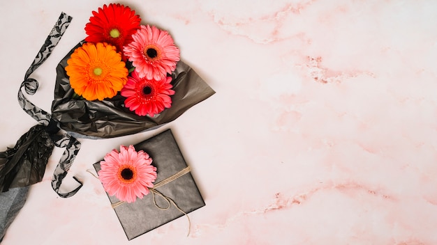 Gratis foto gerbera bloeit op verpakkingsfilm met geschenkdoos