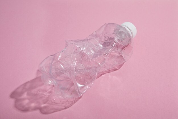 Gerecycleerde plastic fles op roze achtergrond