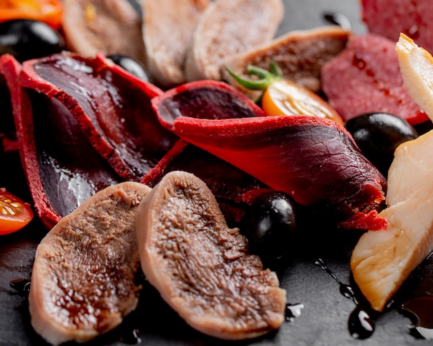 Gerookt vlees geserveerd met olijven en tomaten