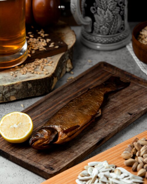Gerookte vis geserveerd met citroen en bier