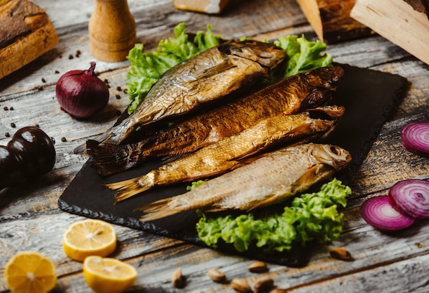 Gerookte vis geserveerd op zwarte portie bord