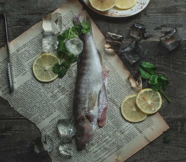 Gerookte vis op papier met plakjes citroen en basilicum