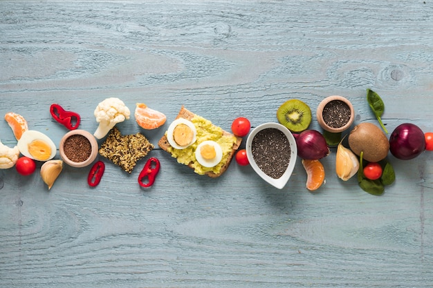 Geroosterd brood; vers fruit en ingrediënten gerangschikt in een rij op houten tafel