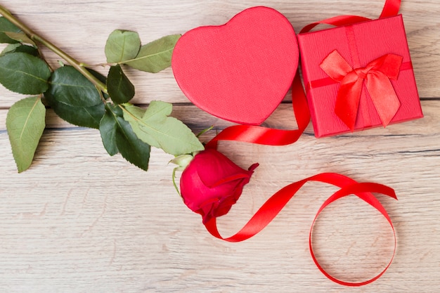 Geschenkdoos met rode roos op houten tafel