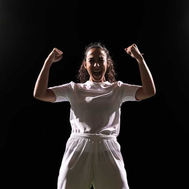 Geschikte vrouw in sportkleding het vieren