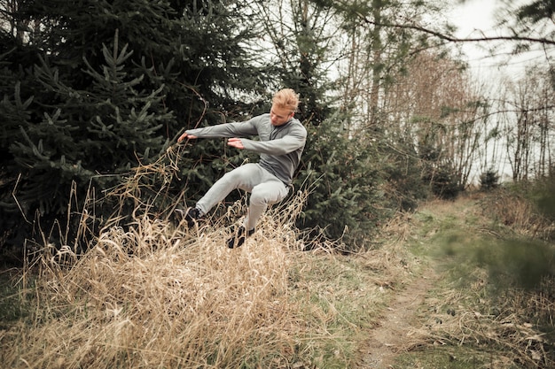 Geschiktheids jonge mens die over het droge gras springt