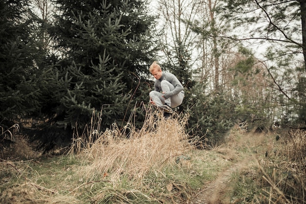 Gratis foto geschiktheids jonge mens die over het gras springt