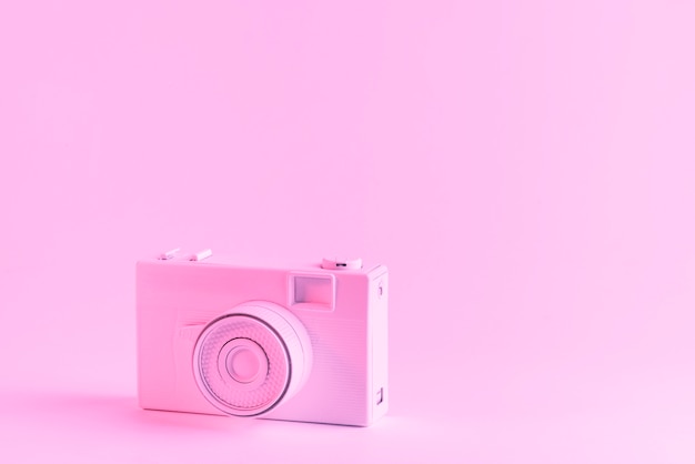 Gratis foto geschilderde roze camera tegen roze achtergrond