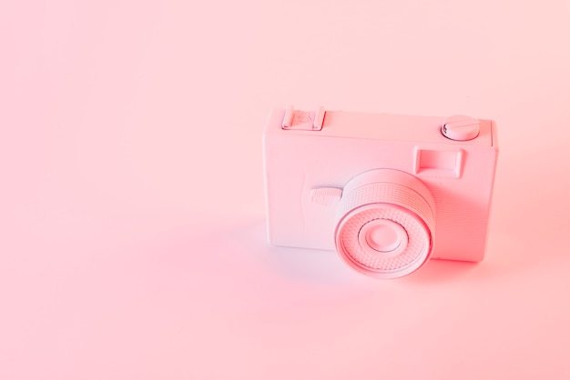 Gratis foto geschilderde roze camera tegen roze achtergrond
