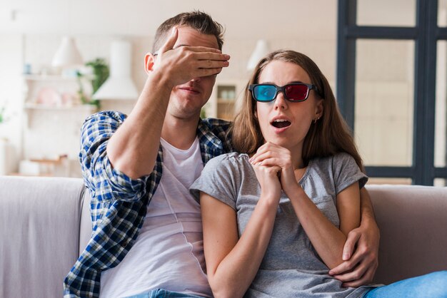 Geschokt paar kijken naar film en knuffelen op bank