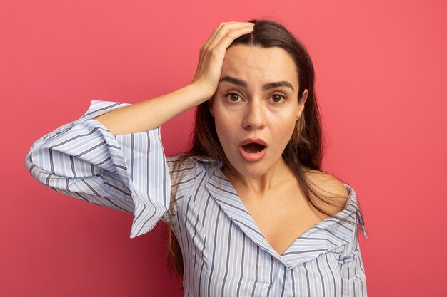 Geschokt vrij blanke vrouw hand op het hoofd op roze