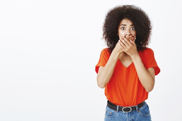 geschokt vrouw met afro kapsel poseren in de studio