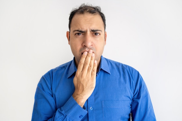 Geschokte Indische mens die mond behandelt met hand