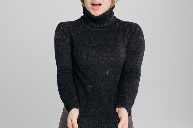 Geschokte vrouw toont haar vuile zwarte trui op camera