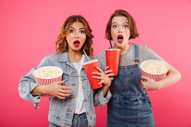 Geschokte vrouwen vrienden eten popcorn kijken film