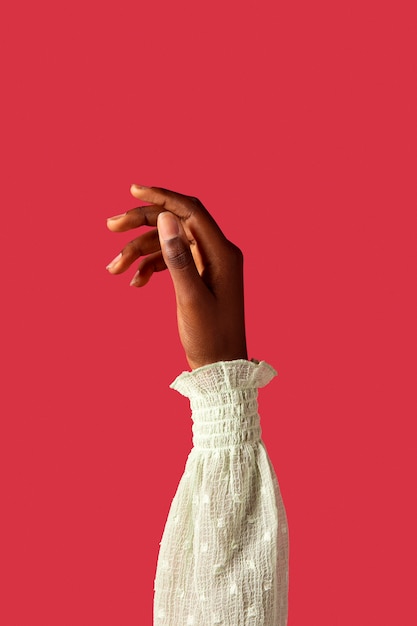 Gratis foto geslacht vloeibare persoon hand geïsoleerd op rood