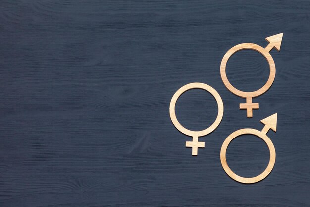 Geslachtssymbolen van mannen en vrouwen, symbool voor gendergelijkheid op zwarte houten achtergrond, copyspace