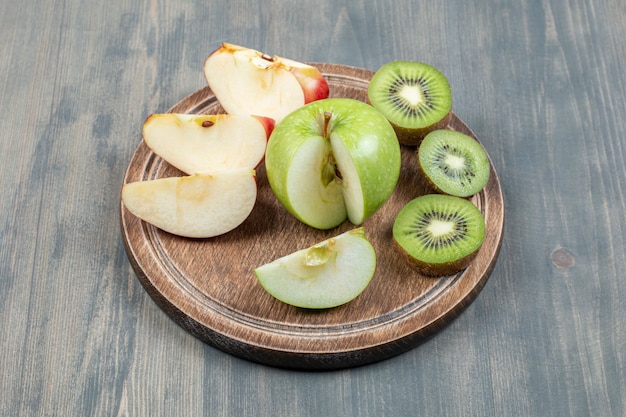 Gratis foto gesneden appels met verse kiwi op een houten tafel