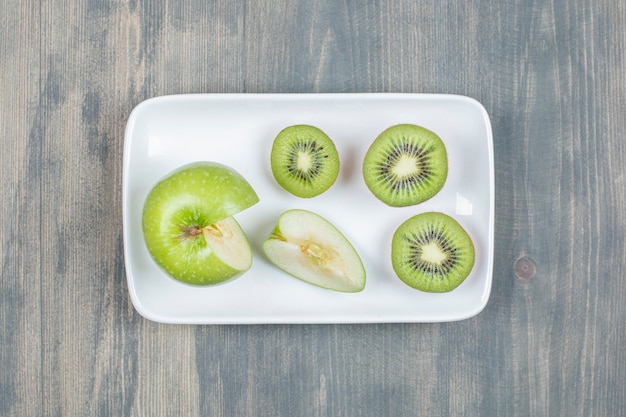 Gesneden appels met verse kiwi op een houten tafel