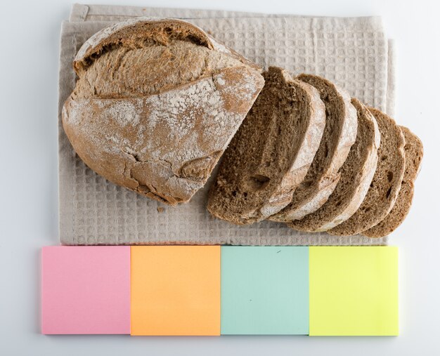 Gesneden brood met kleurrijke sticky notes zijaanzicht op een witte ondergrond