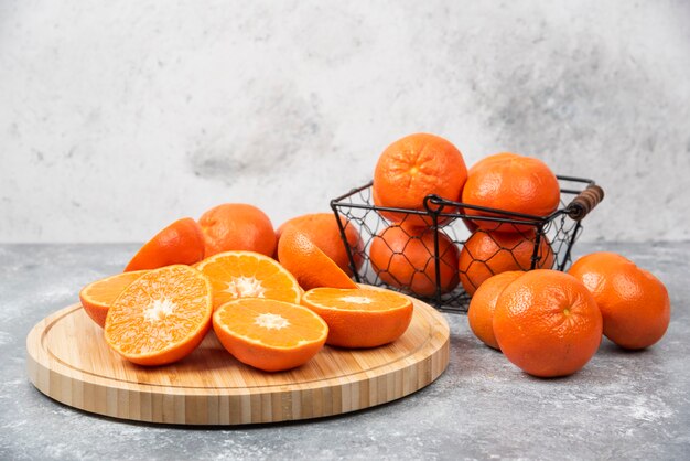Gesneden en geheel sappig vers oranje fruit dat op een steenlijst wordt geplaatst.