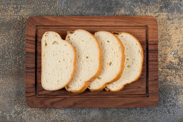 Gesneden geurig brood op een houten bord.