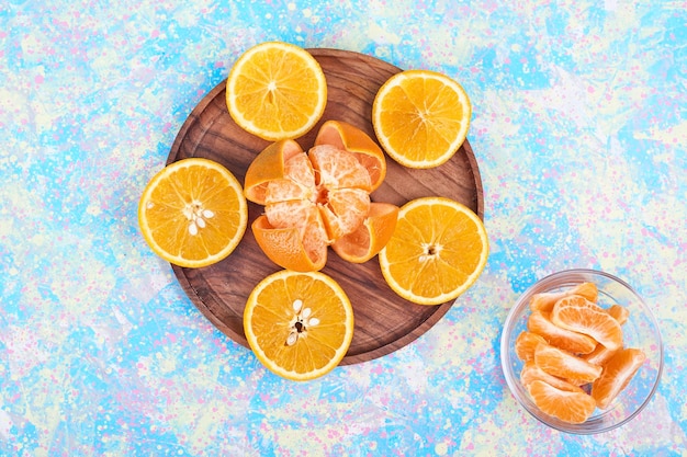 Gratis foto gesneden sinaasappelen en mandarijnen die op een houten schotel worden geïsoleerd. hoge kwaliteit foto