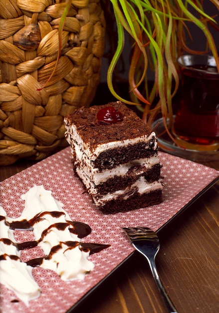 Gesneden Tiramisu-cake gemaakt van chocolade en witte spons. Een stuk van het dessert op houten planken.