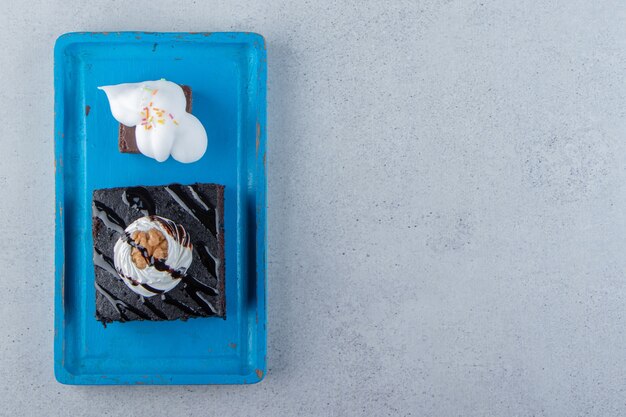 Gesneden van smakelijke chocolade brownie met room op blauw bord. Hoge kwaliteit foto