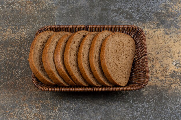 Gesneden vers roggebrood in houten mand.